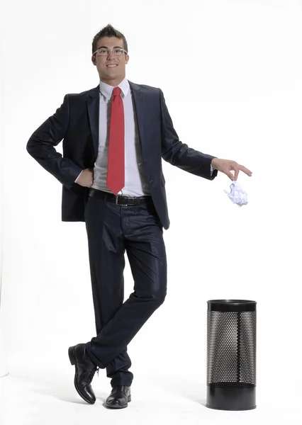 Young businessman dropping a paper in a waste basket. Young businessman dropping a paper in a trash bin. — Stock Photo, Image