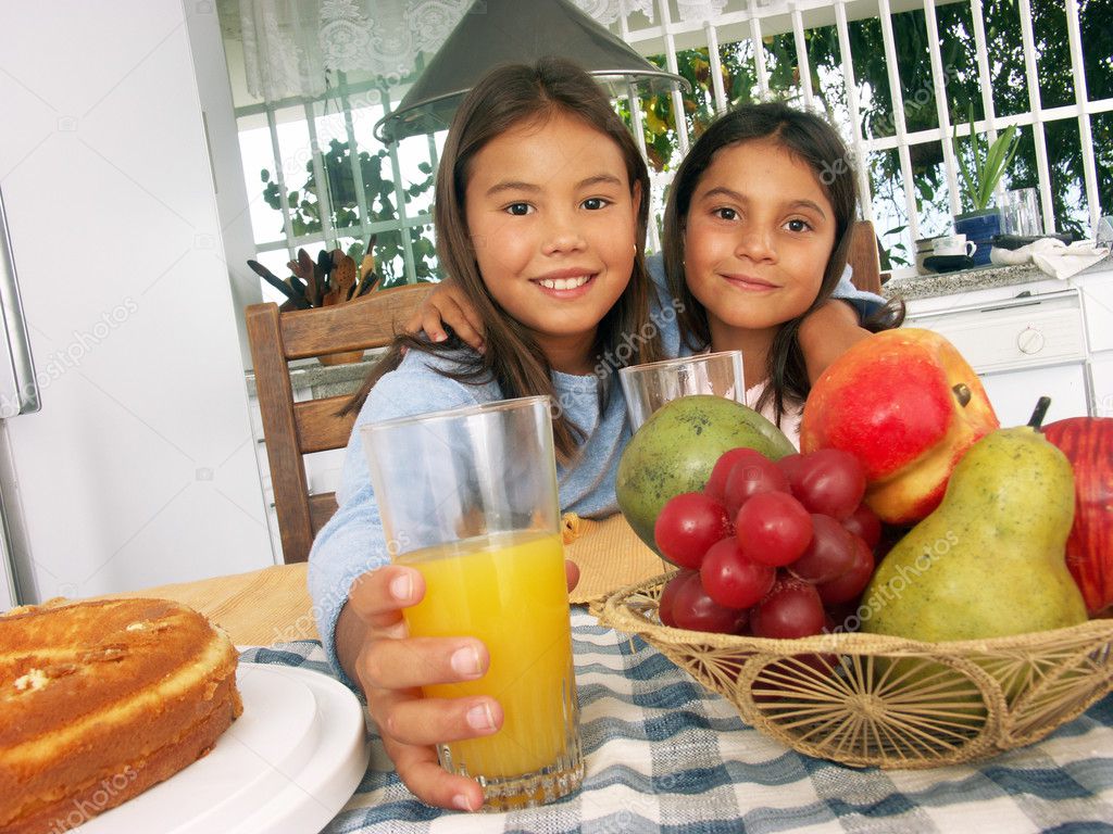 Two little sister having breakfast in a kitchen. Two little girls having breakfast at home.