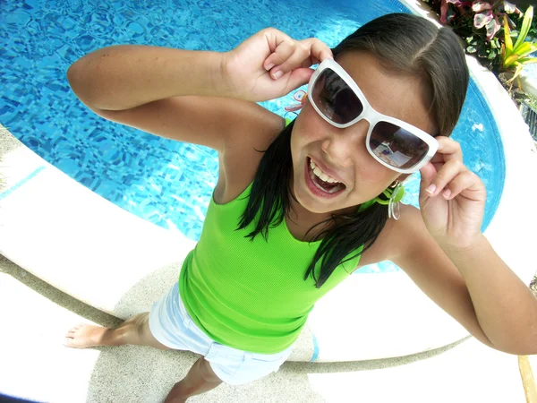 Menina hispânica com óculos de sol desfrutando de uma piscina . — Fotografia de Stock