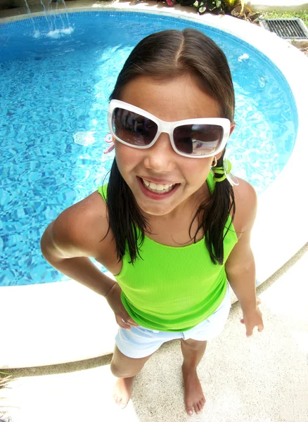 Hispanic girl with sunglasses enjoying a swimming pool. — Stock Photo, Image