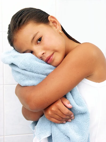 Μικρό κορίτσι αγκαλιάζει μια μπλε πετσέτα. — Φωτογραφία Αρχείου