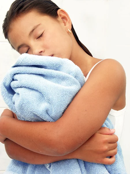 Kleines Mädchen umarmt ein blaues Handtuch. — Stockfoto