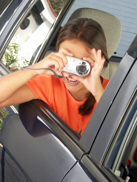 Menina tirando uma foto de uma janela do carro . — Fotografia de Stock