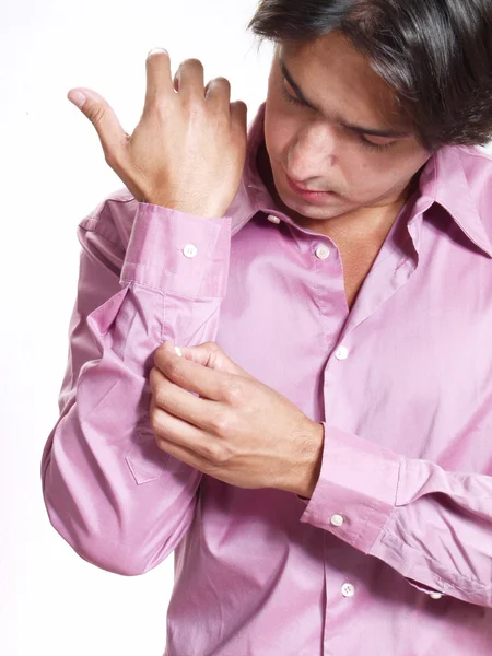 Young hispanic man buttoning his shirt on white background. — Stock Photo, Image