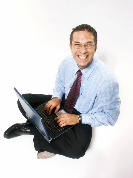 Joven y feliz hombre de negocios que trabaja con un ordenador portátil sobre fondo blanco . — Foto de Stock