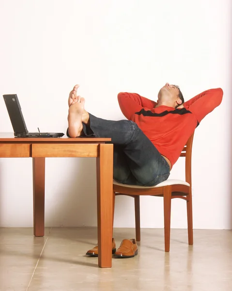 Hombre descansando en un escritorio . — Foto de Stock
