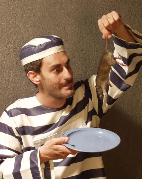 Prisoner eating a rat on a prison cell. — Stock Photo, Image