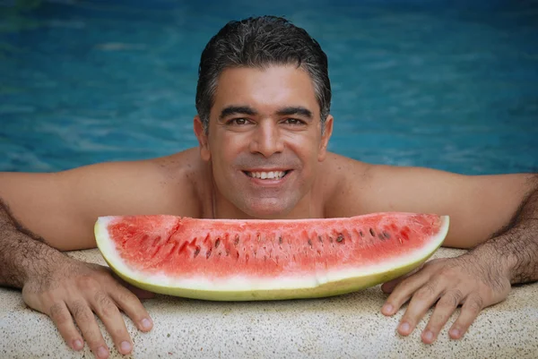 Joven comiendo una gran sandía en una piscina . —  Fotos de Stock