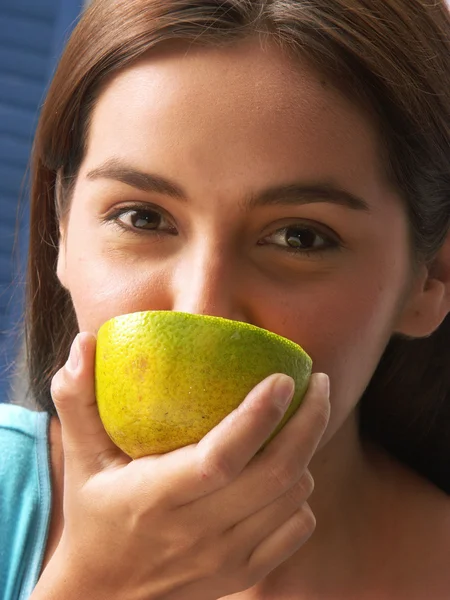 Mujer joven sosteniendo y comiendo limón fresco . —  Fotos de Stock