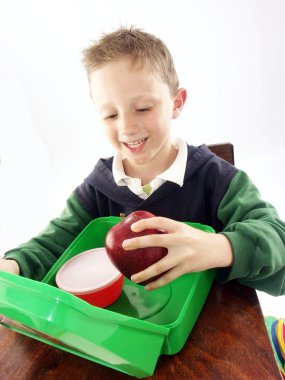Little school kid holding a big red apple. clipart