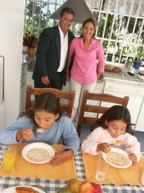 Hispanic family having breakfast in a kitchen. clipart