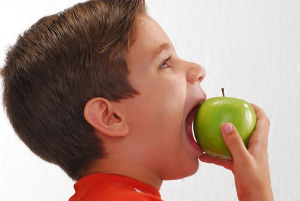 Liten unge äta färskt grönt äpple — Stockfoto