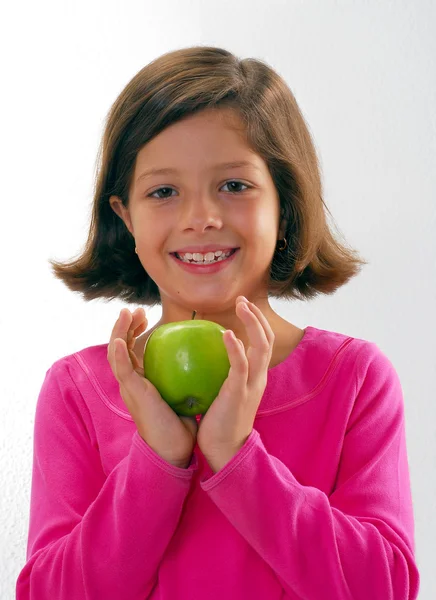 Ragazzina che tiene e mangia mela fresca — Foto Stock