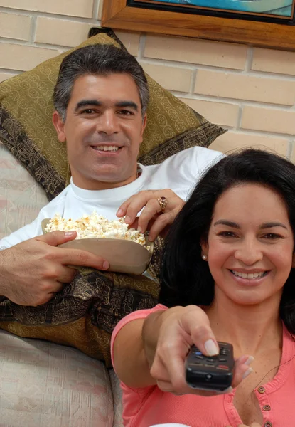 Casal assistindo TV e comendo pipocas. Compartilhamento de casais em uma sala de estar . — Fotografia de Stock