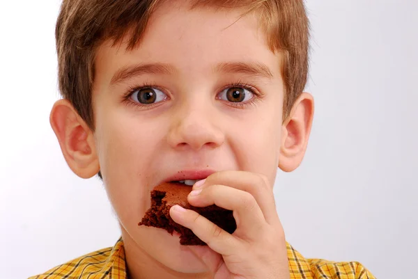 Ragazzino che mangia un brownie al cioccolato — Foto Stock