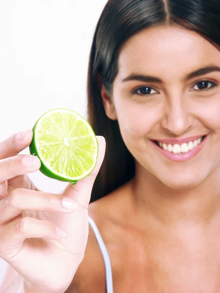 Young woman holding and eating fresh lemon. — Stock Photo, Image