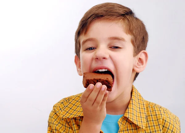 Ragazzino che mangia un brownie al cioccolato — Foto Stock