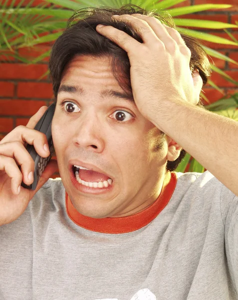 Martw się młody człowiek rozmawia przez telefon komórkowy. — Zdjęcie stockowe
