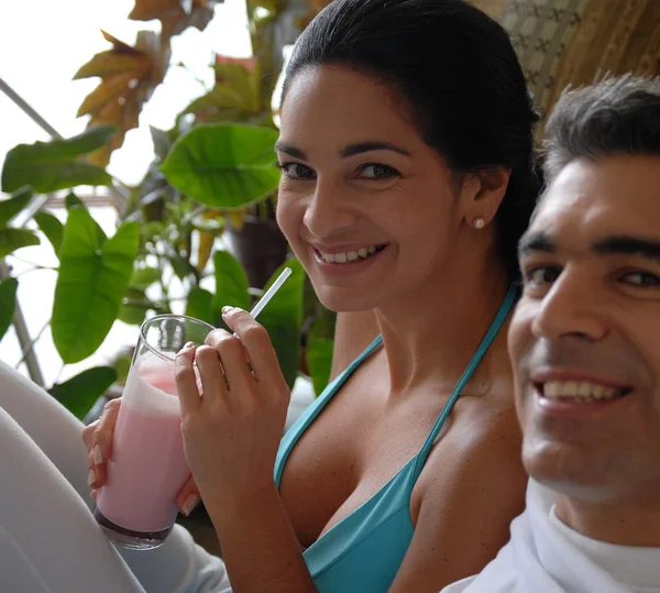 Lateinisches Paar trinkt Erdbeer-Milchshake. — Stockfoto