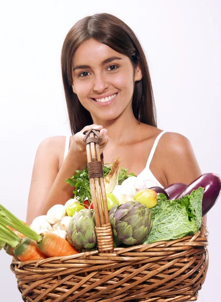 Jeune femme tenant un panier de légumes . — Photo