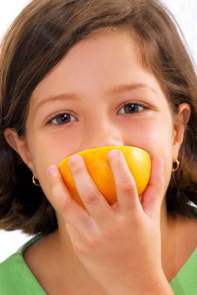 Menina segurando e comendo laranja — Fotografia de Stock