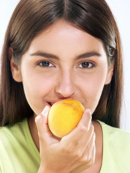 Jonge vrouw eten een perzik — Stockfoto