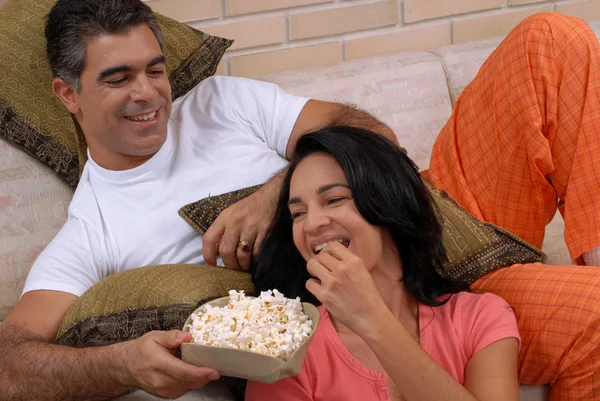 Casal assistindo TV e comendo pipocas. Compartilhamento de casais em uma sala de estar . — Fotografia de Stock
