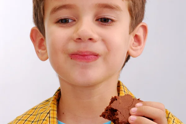 Liten unge äta en choklad brownie — Stockfoto