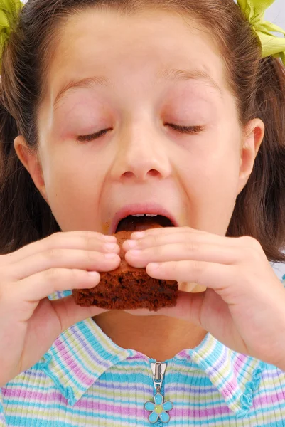 Criança feliz comendo chocolate brownie — Fotografia de Stock