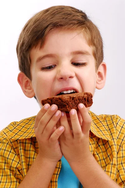 Liten unge äta en choklad brownie — Stockfoto