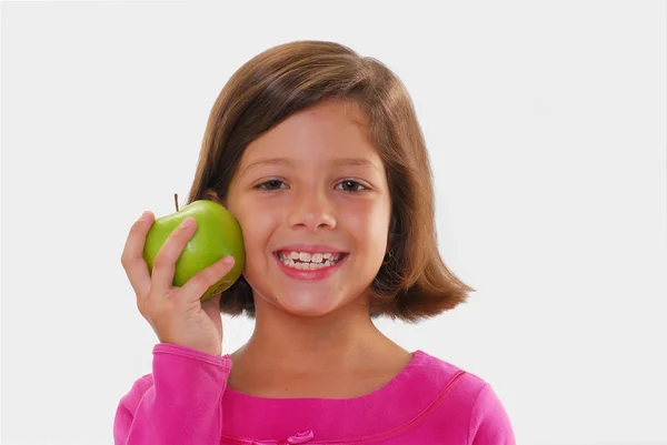 Niña sosteniendo y comiendo manzana fresca — Foto de Stock