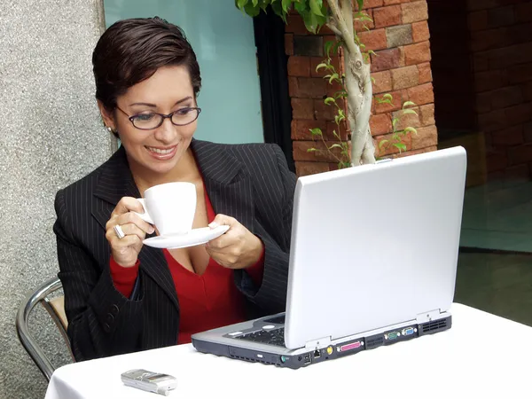 Mulher de negócios em um restaurante que trabalha em um computador . — Fotografia de Stock