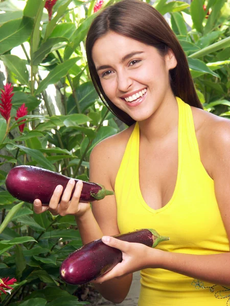 Young woman holding a fresh eggplant on a garden. Stock Photo