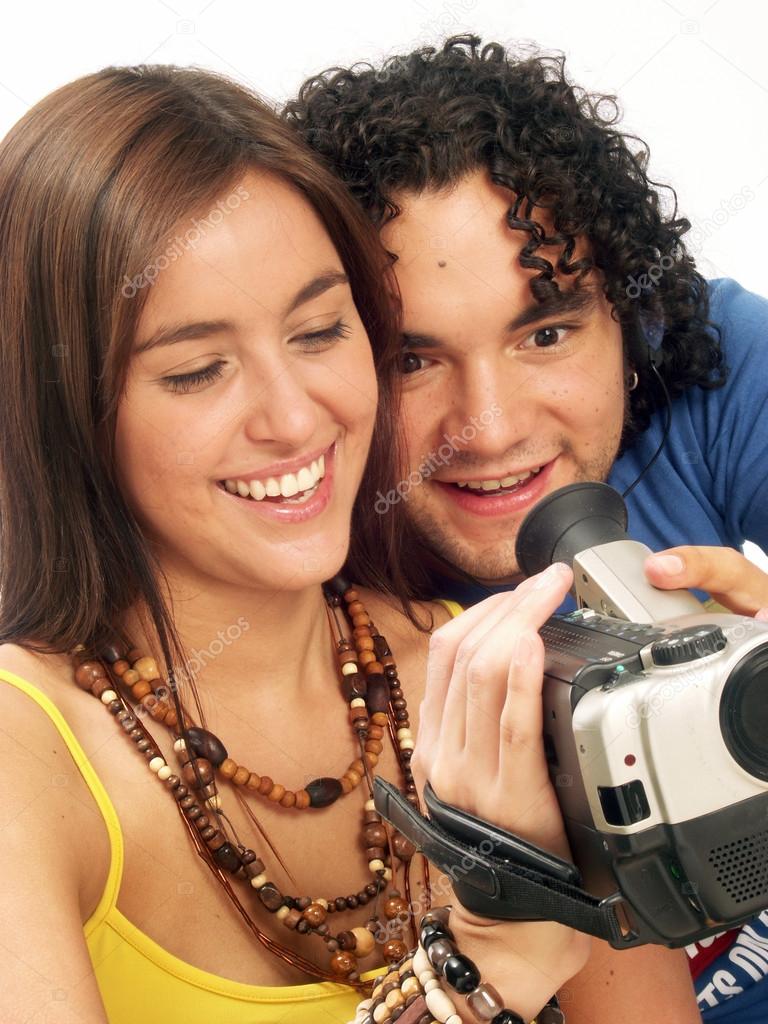 Young couple watching a video camera screen.