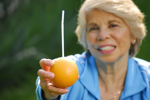 Połowie dorosła kobieta pije sok pomarańczowy. połowie dama dorosły gospodarstwa świeże pomarańcze. — Zdjęcie stockowe