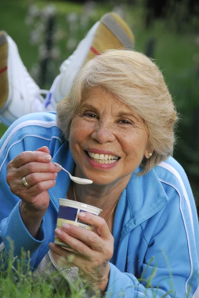 Mid adult woman eating yogurt. — Stock Photo, Image