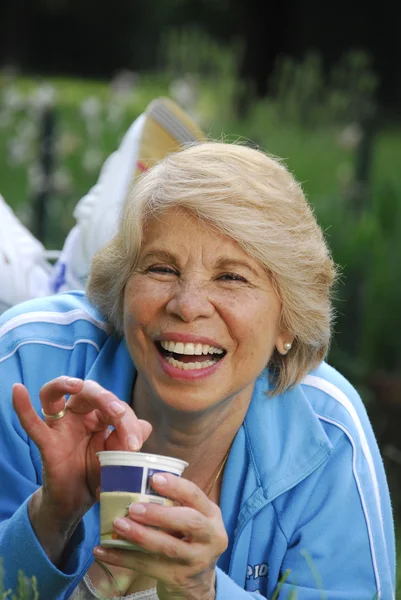 Mid adult woman eating yogurt. — Stock Photo, Image