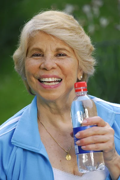 Mujer adulta que sostiene una botella de agua . —  Fotos de Stock