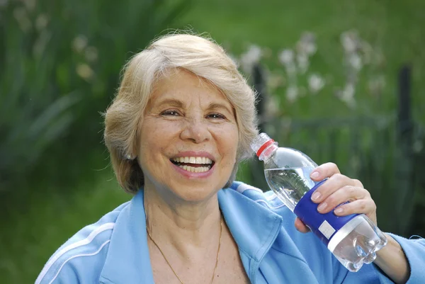 Mid adult woman holding a water bottle. — Stock Photo, Image