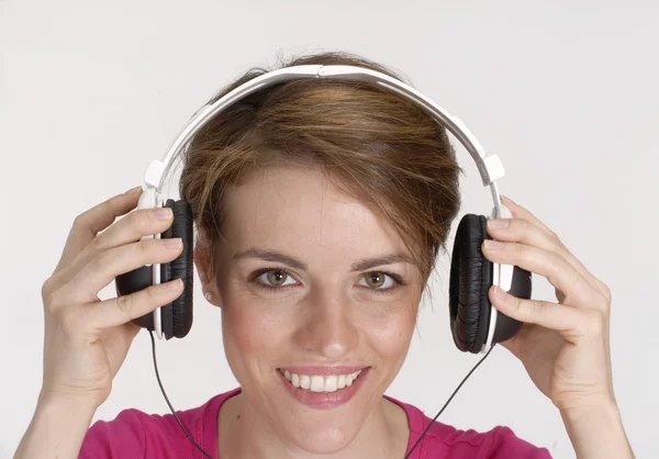 Mladá žena poslech hudby pomocí sluchátek. — Stock fotografie