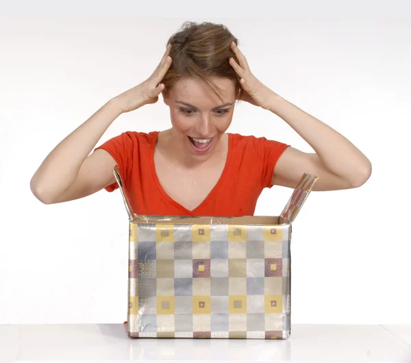 Expressive young woman opening a gift. — Stock Photo, Image