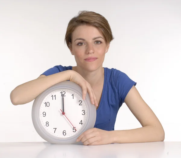 Młoda kobieta trzyma zegar na białym tle. — Zdjęcie stockowe