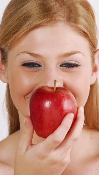 Jovem loira comendo uma maçã vermelha . — Fotografia de Stock