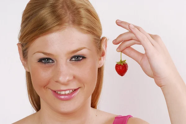 Young woman holding a fresh strawberry on white portrait. — Stock Photo, Image