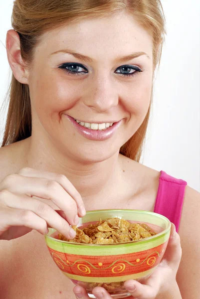Jonge vrouw eten en houden een kom van granen. — Stockfoto