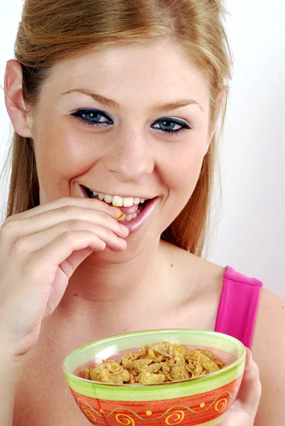 Jovem mulher comendo e segurando uma tigela de cereais . — Fotografia de Stock