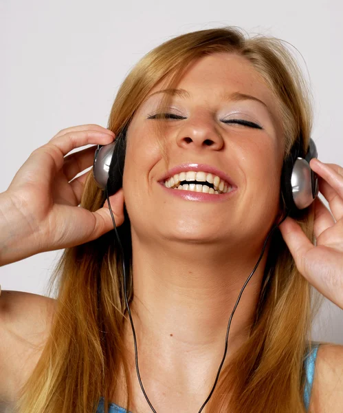 Mujer joven escuchando música usando auriculares . —  Fotos de Stock