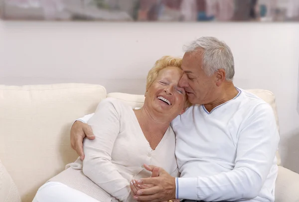 Casal sênior compartilhando e sorrindo em casa . — Fotografia de Stock