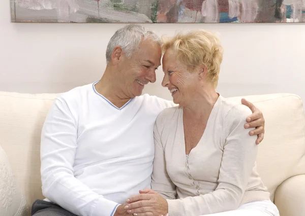 Casal sênior compartilhando e sorrindo em casa . — Fotografia de Stock