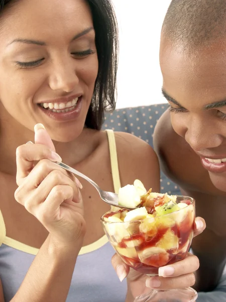 Jovem casal hispânico desfrutando e comendo salada de frutas na cama . — Fotografia de Stock